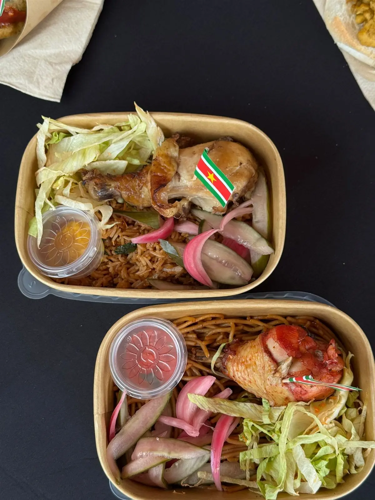 Maaltijdbakjes met kip en bami en een Surinaams vlaggetje